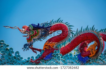 A pair of dragon statues on the roofs of a Chinese temple with a beautiful blue sky background,Beautiful pictures of temples, temples, Bangkok Taken in Thailand