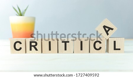 Critical Word Written In Wooden Cube on white background