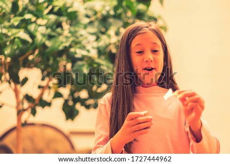 Girl playing with matches. Dangerous situation at home. A small child plays with matches, a fire, a fire flares up, danger, child and matches, lucifer match. toned Royalty-Free Stock Photo #1727444962
