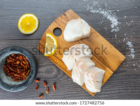 chopped cod on a wooden board on white