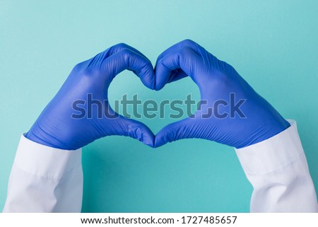 Top above overhead view photo of doctor in gloves making a heart shape isolated on teal blue turquoise background