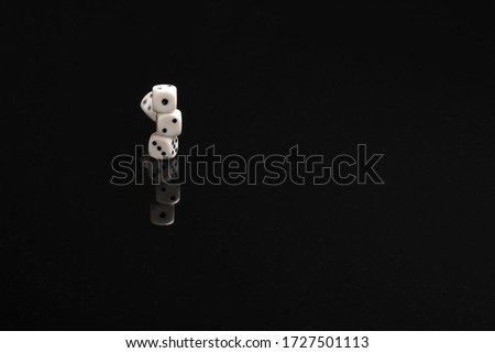 Pile of dices just about to fall on a black table