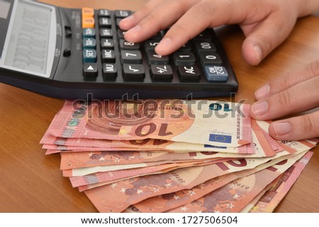 Close-up of a black calculator and 10 euro bills symbolising economy, accounting, bills payement. 