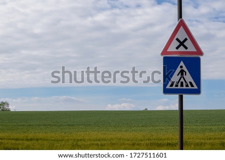 Street signs in front of field