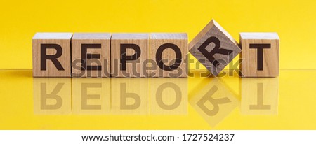 REPORT message word on a wooden desk on cube blocks with a green nature background