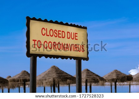 Concept for coronavirus pandemic and toruism crisis. Sign on beach with "closed due to coronavirus".