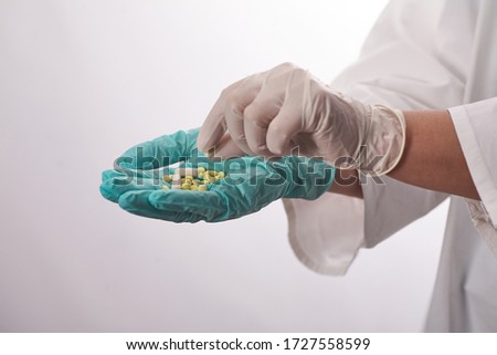The pills are in the doctor's hands. Hands in medical gloves hold pills. Medicine for the disease.