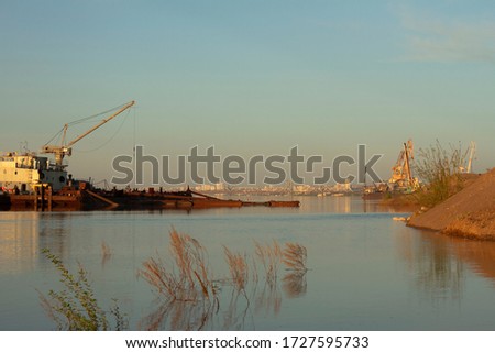 industrial landscape. river floating crane and port cranes on the background of bridges and the city