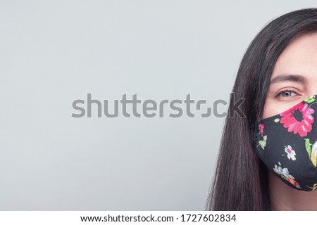 Woman portrait in serious mood with face mask, physycal distancing mood.