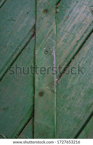 Wooden surface painted in green color. With a cross iron bar. Empty frame worn and damaged.