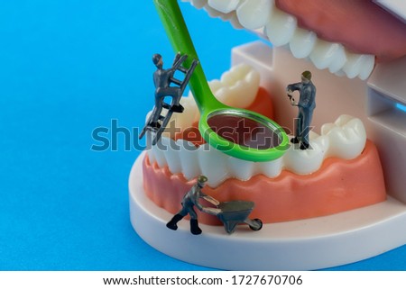 Mechanic model Miniature people cleaning tooth model as medical and healthcare concept, Regular checkups are essential to oral health on blue background.
concept: medical and healthcare, people  