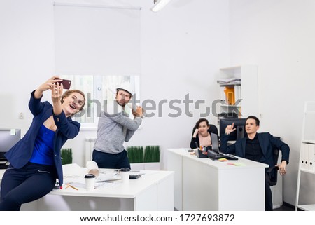 Four people taking a funny selfie in the office