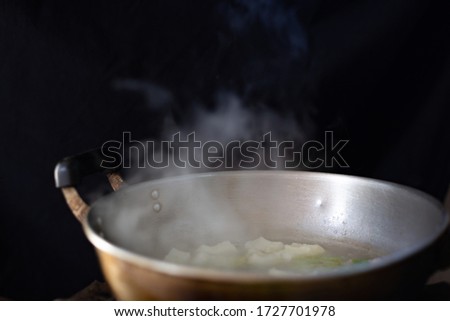 Blurred white smoke from pot stainless steel cooking with black background in countryside kitchen.soft picture
