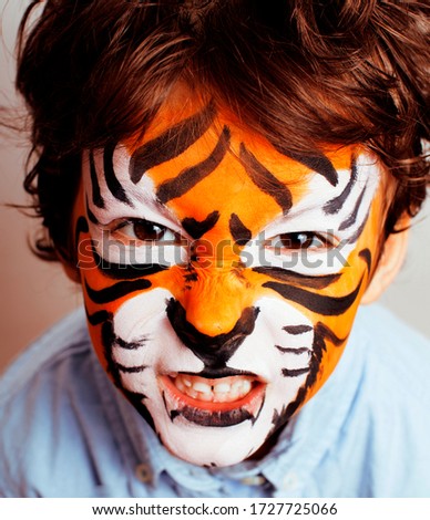 little cute boy with faceart on birthday party close up, little cute tiger, lifestyle people concept