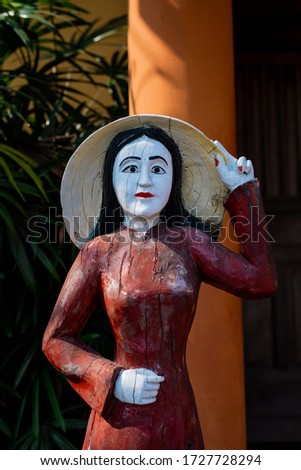 Wooden statue of a Vietnamese woman in traditional clothing in the ancient city of Hoi an. Vietnam