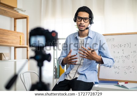 Asian school male teacher working from home teaching online math subject to student studying from home. Man using camera to record his live in internet. Remote education class during covid19 pandemic. Royalty-Free Stock Photo #1727728729