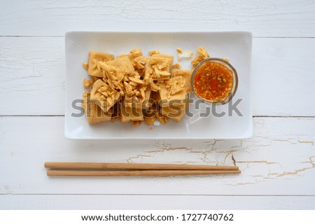 Deep fried tofu is cut into square balls on plate , asian food