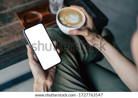 cell phone Mockup image blank white screen.woman hand holding texting using mobile on desk at coffee shop.background empty space for advertise.work people contact marketing business,technology