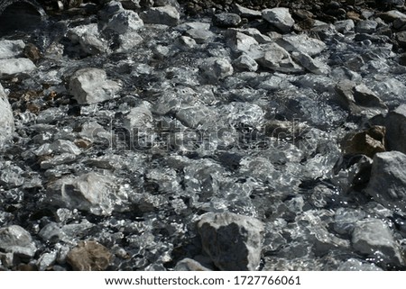 clear water runs through the grey stones, background