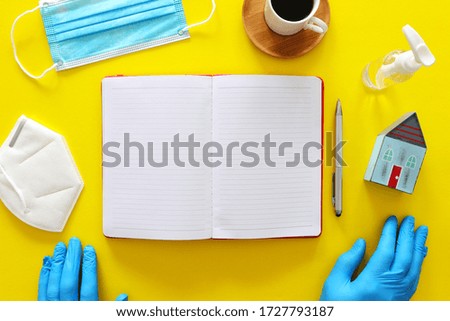 concept image of home office. Covid-19 Coronavirus quarantine with empty notebook over yellow background