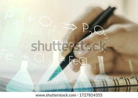 Creative chemistry hologram with man hand writing in notepad on background, pharmaceutical research concept. Multiexposure