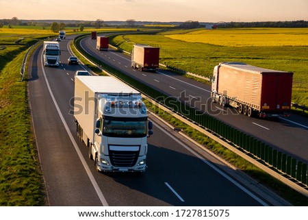 heavy truck traffic on the highway in the evening Royalty-Free Stock Photo #1727815075