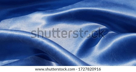 Blue satin fabric in folds - in the sun (texture).