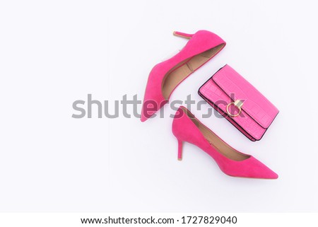 
A fashion pair high hell pink shoes with pink purse studio shot on white background
