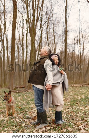 Seniors in a forest. People walks. Family with dog.