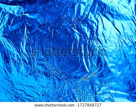 Blue shiny wrinkled aluminum foil as background