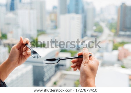 Woman holding Plastic Cutlery set with Fork and Spoon on background blur in city. Online delivery service, Virus outbreak  concept.