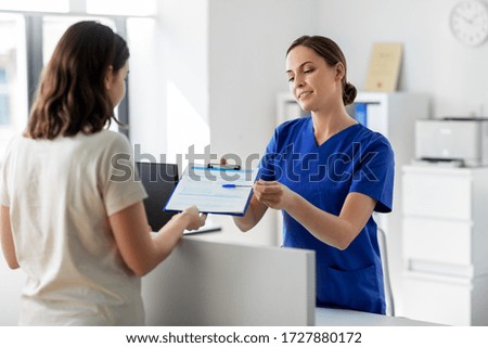 medicine, people and healthcare concept - female doctor or nurse with clipboard and patient at hospital Royalty-Free Stock Photo #1727880172