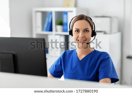 medicine, technology and healthcare concept - happy smiling female doctor or nurse with headset and computer working at hospital Royalty-Free Stock Photo #1727880190