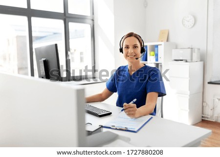 medicine, technology and healthcare concept - happy smiling female doctor or nurse with headset and computer working at hospital Royalty-Free Stock Photo #1727880208