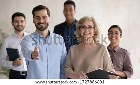 Close up headshot portrait of two happy businessman shaking hand posture and mature businesswoman looking at camera. Diverse smiling employee standing behind of male and female company mentors. Royalty-Free Stock Photo #1727886601