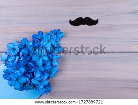 Happy birthday greeting card concept father's day or anniversary on wood table background, Bow tie, with blue flowers, top view.