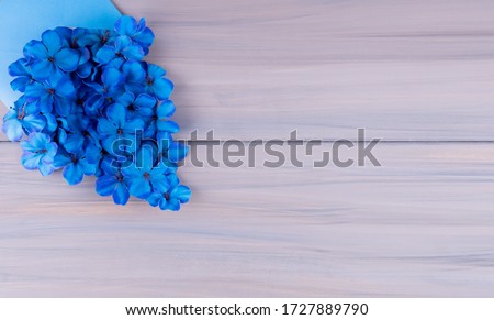 Father's day greeting card concept, copy space for text on a wooden background with blue flowers and hat.