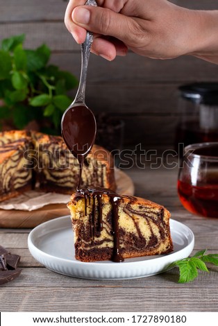 Homemade marble cake with chocolate on a plate. Chocolate dripping from a spoon
