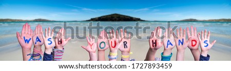 Kids Hands Holding Word Wash Your Hands, Ocean Background