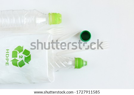 Various disposable plastic Cutlery and bottles. Concept of plastic recycling and ecology on a white background