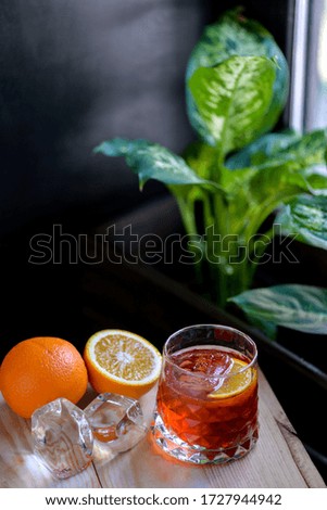 red alcoholic cocktail in a beautiful glass on a dark background with a flower vertical photo
