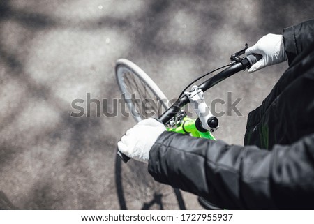 Women wearing plastic gloves and holding bicycle handlebar