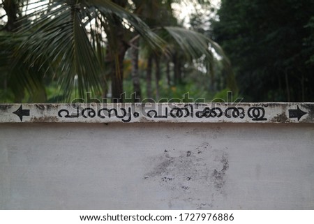 post no bills warning sign in malayalam language on a white wall