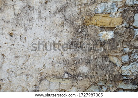 Picturesque texture. Old wall with cracked masonry, covered with stucco. Textured surface. Close up.