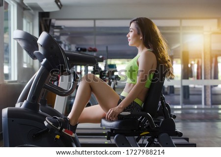 close up picture  the woman is exercise legs on a recumbent bike in the gym 