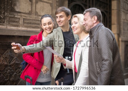 group of tourists taking selfie on old street of European city