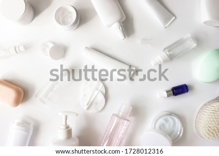 White squeeze tube, bottle of cream, shampoo, deodorant, soap, cleanser, body brush, cotton pads, buds flat lay on white background top view. Beauty skincare, natural cosmetic products. Stock photo