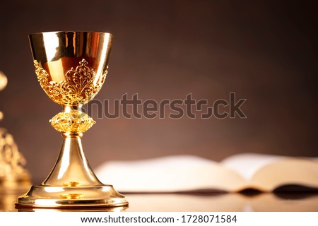 Christianity symbols on dark background. Altar cross, Jesus figure, monstrance, church candle, chalice, rosary, bible. Royalty-Free Stock Photo #1728071584
