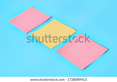 Row of yellow and red square blank paper stickers on blue background