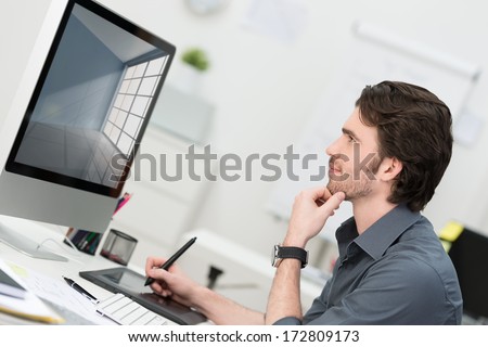 Businessman using a tablet and pen to navigate on his desktop computer in the office sitting in profile thinking and reading the monitor Royalty-Free Stock Photo #172809173